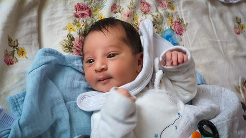 Portrait of cute baby lying on bed