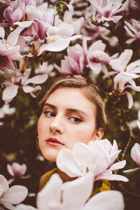 Young woman amidst pink flowers during springtime