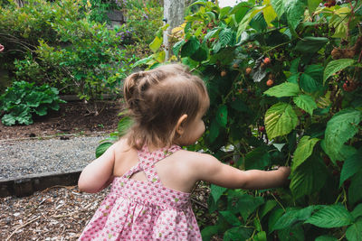 Girl with plants against trees