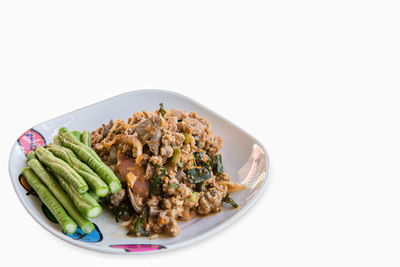 Close-up of food in plate against white background