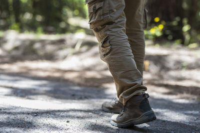 Low section of man walking on road