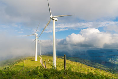 Windmill on field against sky