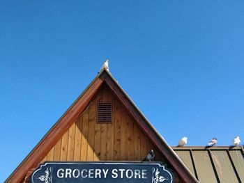 Low angle view of store against clear blue sky