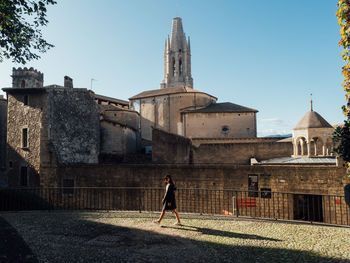 Man walking in historic building against clear sky