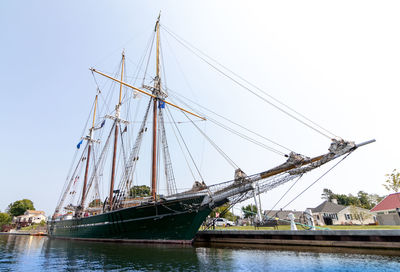 Sailboats sailing on river against sky