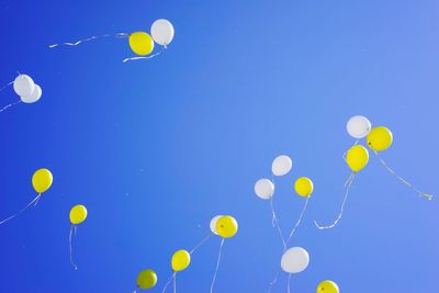 Low angle view of balloons against blue sky