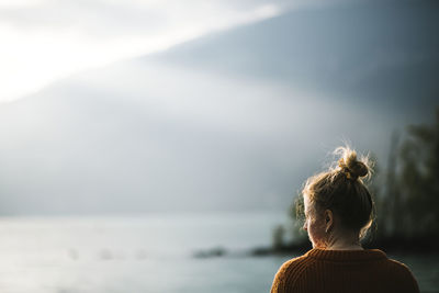 Rear view of woman looking at sea against sky