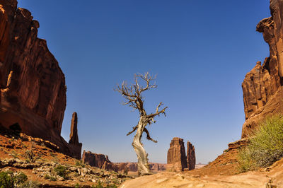 Low angle view of rock formations against clear blue sky