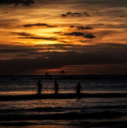 Silhouette man on beach against sky during sunset