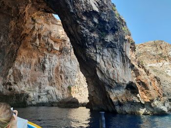 Rock formations by sea against sky