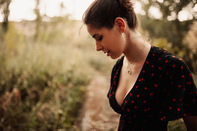 Close-up of woman looking down while standing on field