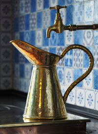 Antique metallic pitcher on table
