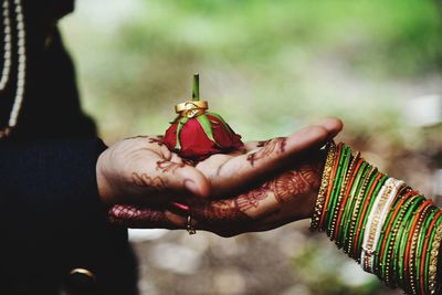 Close-up of hand holding red bell outdoors
