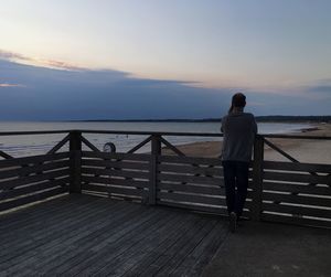 Rear view of woman looking at sea against sky