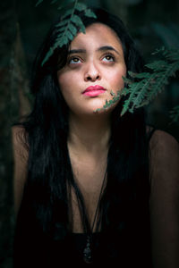 Close-up of thoughtful young woman in forest