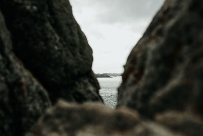 Close-up of rock formation in sea against sky