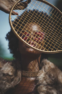 Close-up portrait of woman holding racket