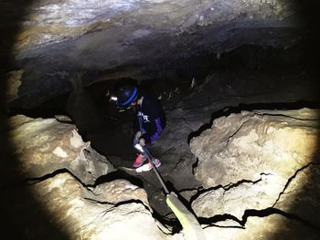 Person standing on rock formation in cave