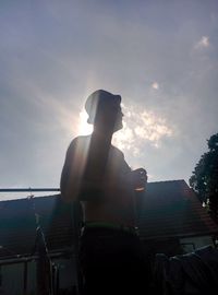 Low angle view of sun shining through clouds