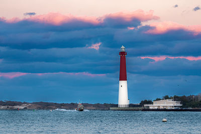 Coast guard boat patrolling alongside barneget lighthouse.