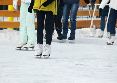 Low section of people walking on snow