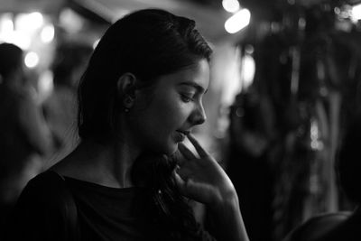 Close-up of young woman standing outdoors at night