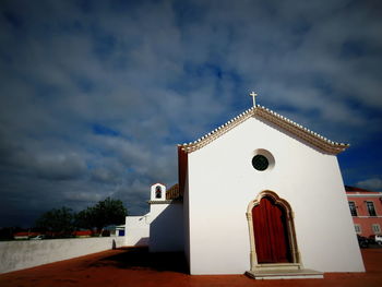 Low angle view of church against cloudy sky