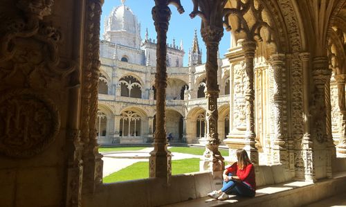 Woman sitting in corridor of historic building