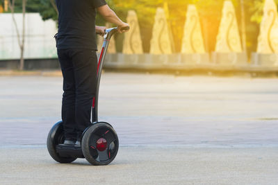 Low section of man riding segway on road