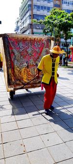 Rear view of woman walking on footpath in city