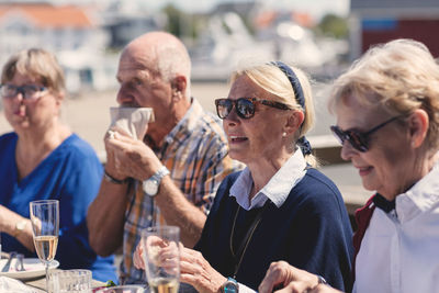 Happy senior woman having lunch with friends at outdoor restaurant