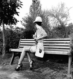 Full length of woman sitting on bench 