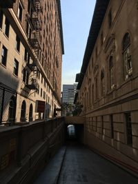 Empty alley amidst buildings in city against sky