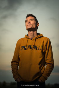 Portrait of young man standing against sky