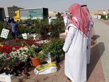 Rear view of people standing at market stall