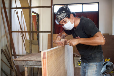 Serious carpenter working at home