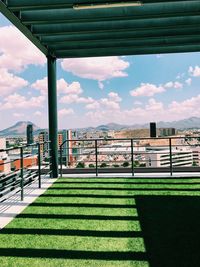Scenic view of park by buildings against sky