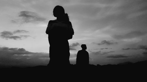 Silhouette couple standing against sky during sunset