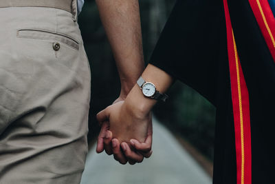 Midsection of couple holding hands