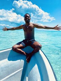 Rear view of shirtless man swimming in sea