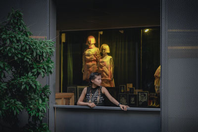 Rear view of woman standing by window