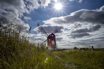 Traditional windmill on field against sky