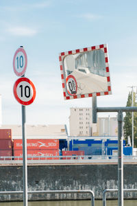 Road sign against sky in city