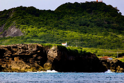 Scenic view of mountain by sea against sky