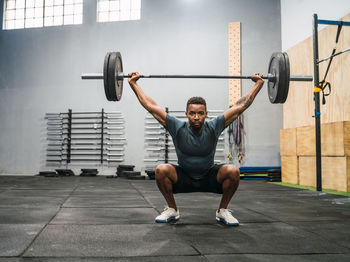 Full length of man exercising in gym