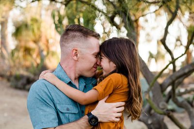 Dad & daughter embracing in desert garden in san diego