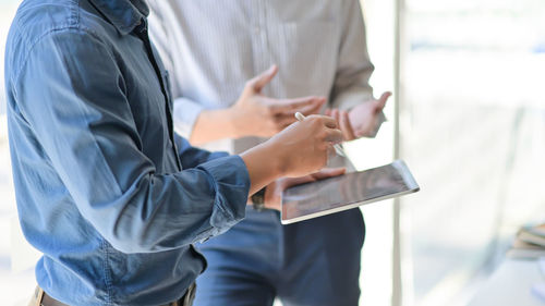 Midsection of man using mobile phone