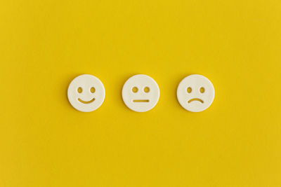 Close-up of smiley face against yellow background