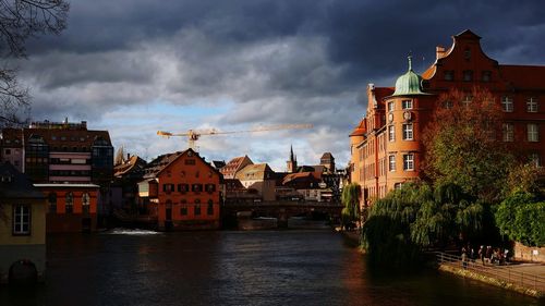 Houses in city against cloudy sky