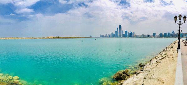 Panoramic view of sea and buildings against sky